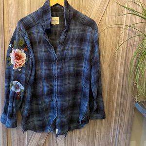 Deconstructed flannel shirt with floral embroidery.